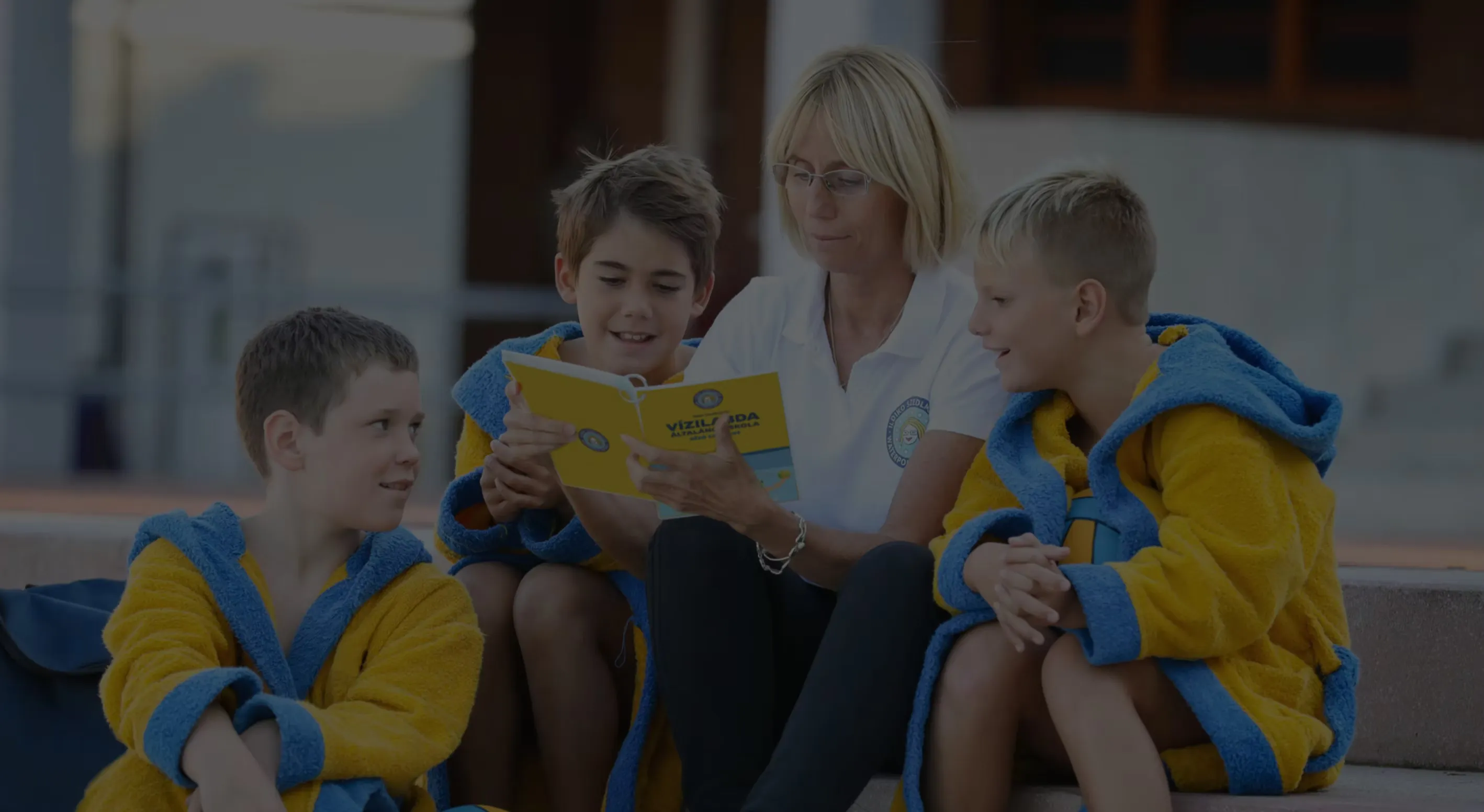 Young players in club robes reading the book together